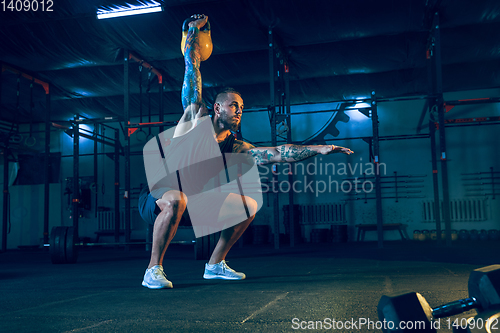 Image of Young healthy man athlete doing exercise in the gym