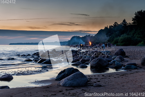 Image of Unrecognisable people celebrating summer solstice with bonfires on beach