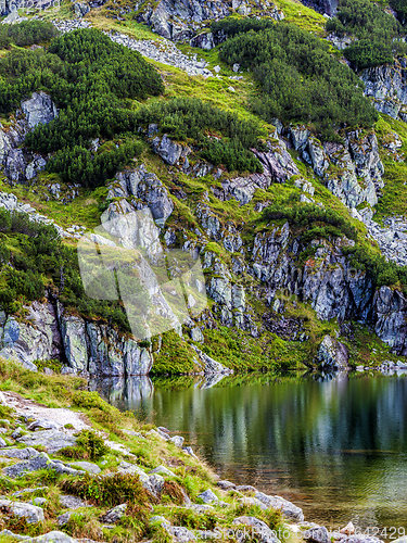 Image of Mountain slope with small lake at botom