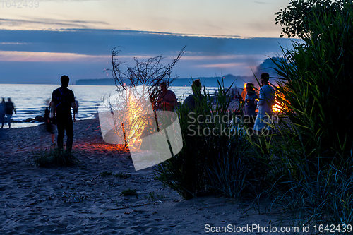 Image of Unrecognisable people celebrating summer solstice with bonfires on beach