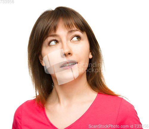 Image of Young happy woman is looking up and smile