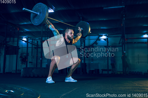 Image of Young healthy man athlete doing exercise in the gym