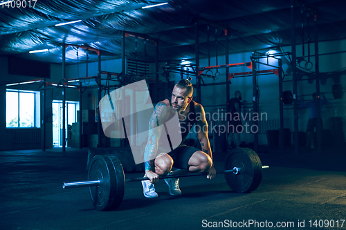 Image of Young healthy man athlete doing exercise in the gym