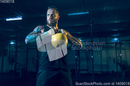 Image of Young healthy man athlete doing exercise in the gym
