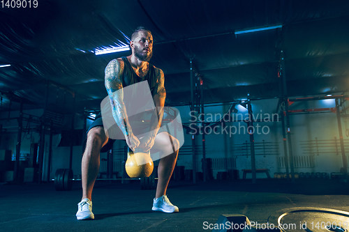 Image of Young healthy man athlete doing exercise in the gym