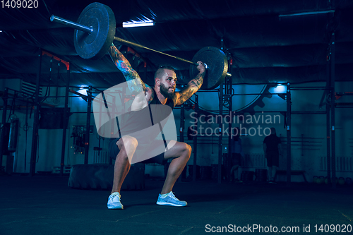 Image of Young healthy man athlete doing exercise in the gym