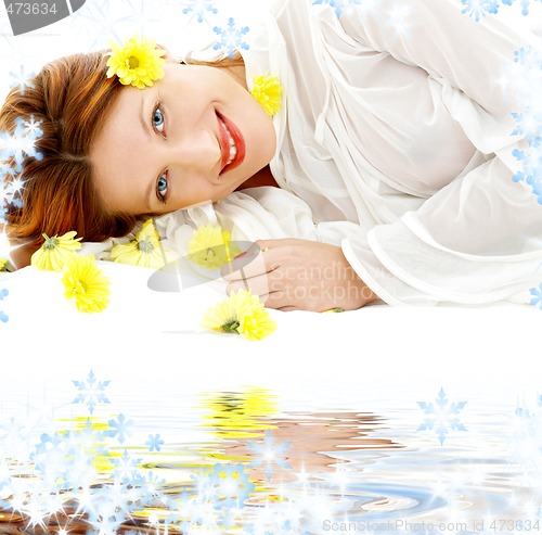 Image of beauty with yellow flowers on white sand