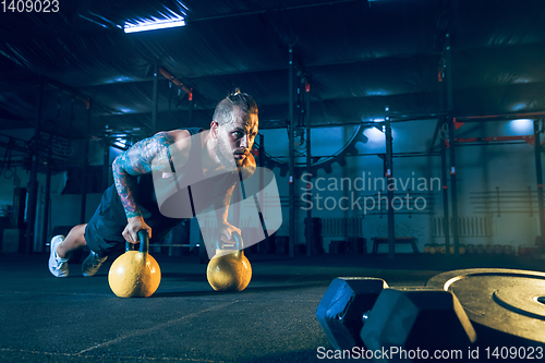 Image of Young healthy man athlete doing exercise in the gym