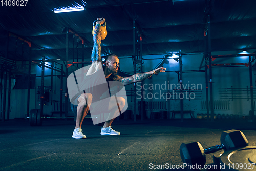 Image of Young healthy man athlete doing exercise in the gym