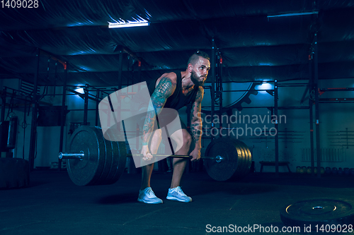 Image of Young healthy man athlete doing exercise in the gym