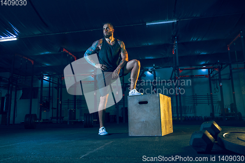 Image of Young healthy man athlete doing exercise in the gym