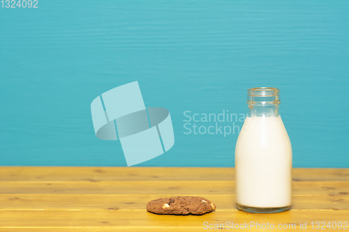 Image of Milk in a glass bottle and a chocolate chip cookie