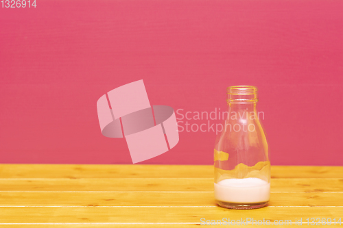 Image of One-third pint milk bottle with dregs of strawberry milkshake