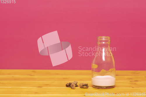 Image of Bottle half full of strawberry milkshake with cookie crumbs