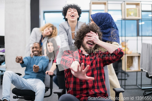 Image of multiethnics business team racing on office chairs