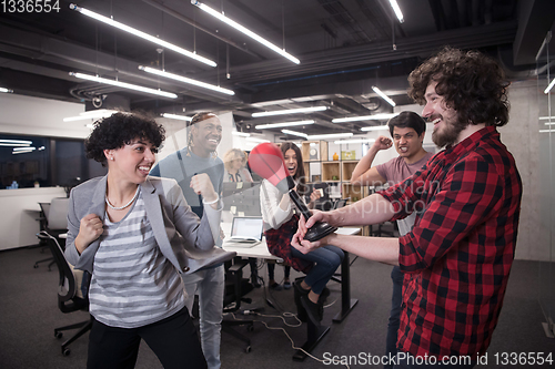 Image of multiethnics business team boxing at office