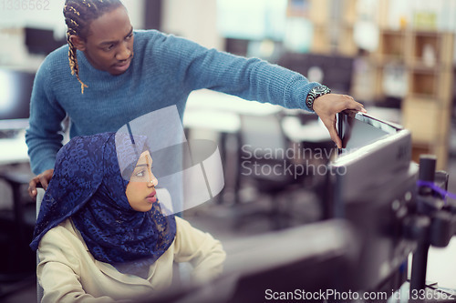 Image of young black muslim female software developer at work