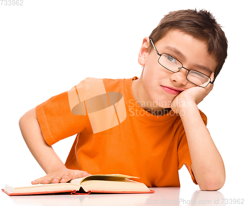 Image of Little boy is tired to read his book