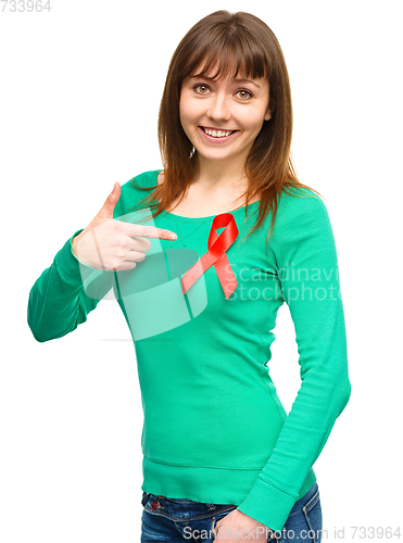 Image of Woman is pointing to the red awareness ribbon