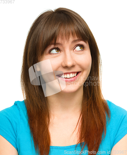 Image of Young happy woman is looking up and smile