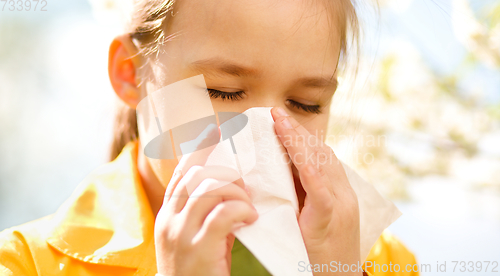 Image of Little girl is blowing her nose