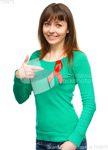 Image of Woman is pointing to the red awareness ribbon