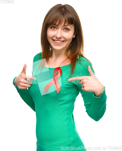 Image of Woman is pointing to the red awareness ribbon