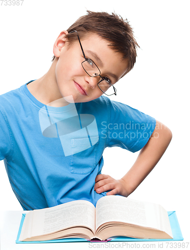 Image of Young boy is daydreaming while reading book