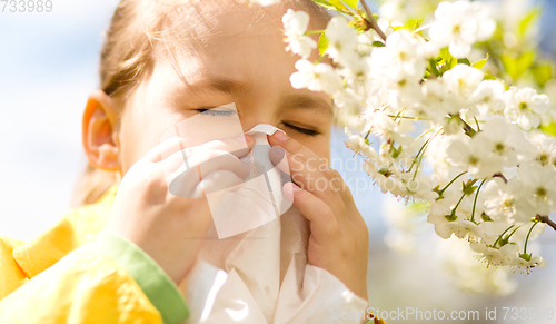 Image of Little girl is blowing her nose