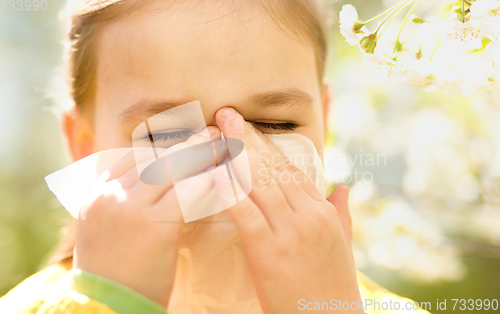 Image of Little girl is blowing her nose