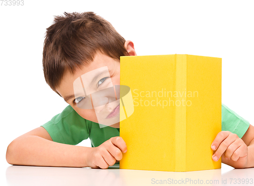 Image of Little boy plays with book