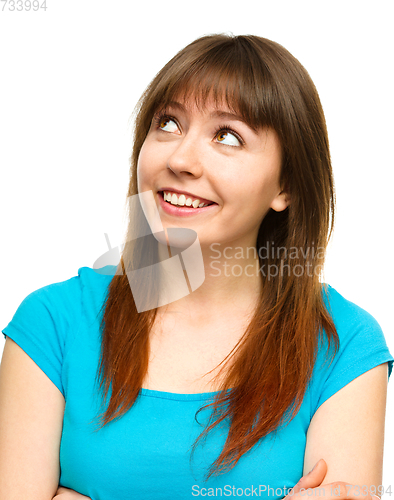 Image of Young happy woman is looking up and smile