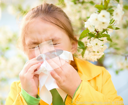 Image of Little girl is blowing her nose