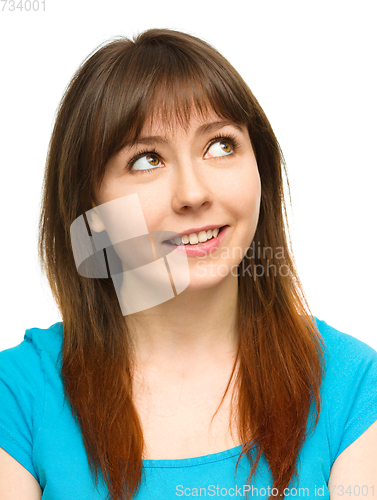 Image of Young happy woman is looking up and smile