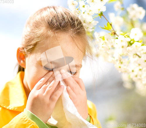 Image of Little girl is blowing her nose