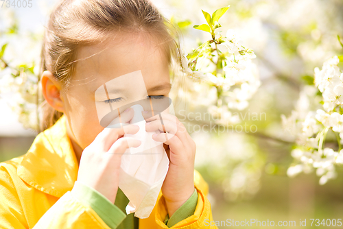 Image of Little girl is blowing her nose