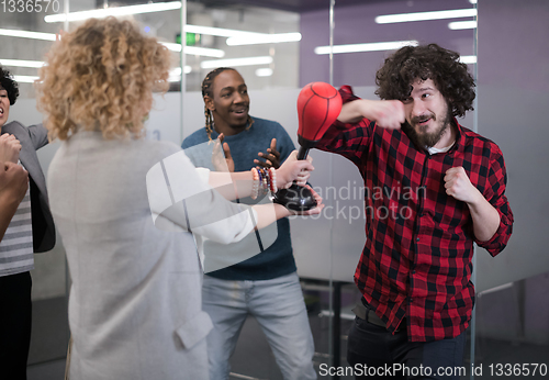 Image of multiethnics business team boxing at office