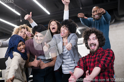 Image of portrait of young excited multiethnics business team
