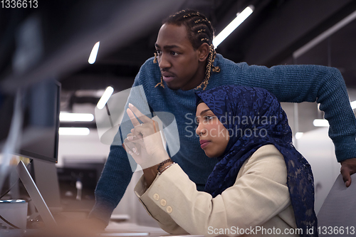 Image of young black muslim female software developer at work