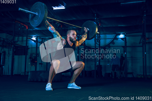 Image of Young healthy man athlete doing exercise in the gym