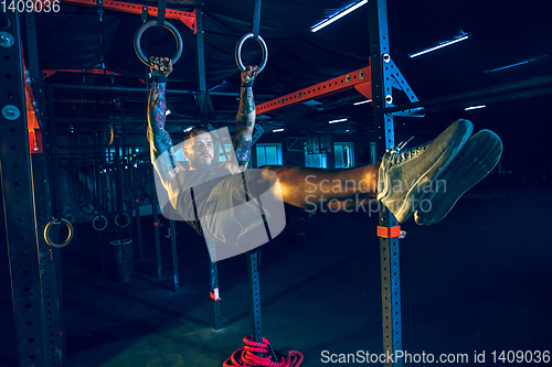 Image of Young healthy man athlete doing exercise in the gym