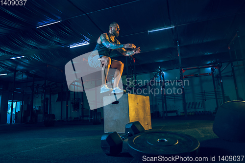 Image of Young healthy man athlete doing exercise in the gym