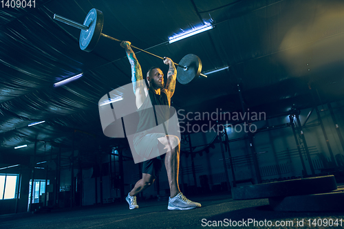 Image of Young healthy man athlete doing exercise in the gym