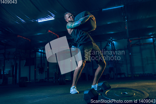 Image of Young healthy man athlete doing exercise in the gym