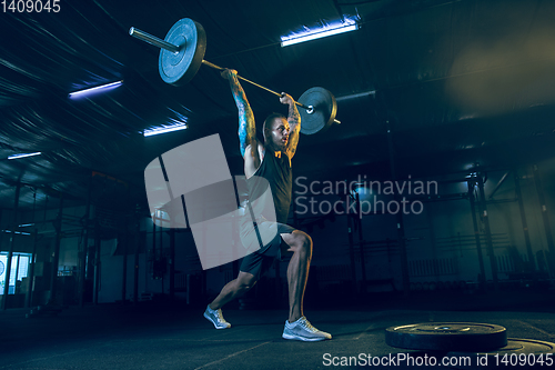 Image of Young healthy man athlete doing exercise in the gym