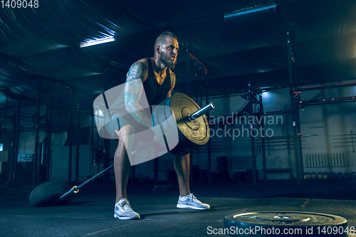 Image of Young healthy man athlete doing exercise in the gym