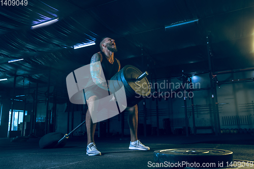 Image of Young healthy man athlete doing exercise in the gym