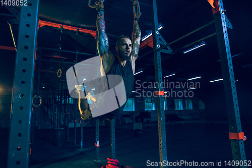 Image of Young healthy man athlete doing exercise in the gym