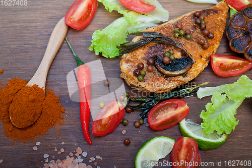 Image of wood fired hoven cooked chicken breast on wood board 