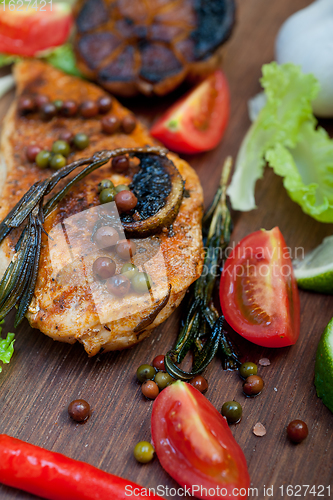 Image of wood fired hoven cooked chicken breast on wood board 